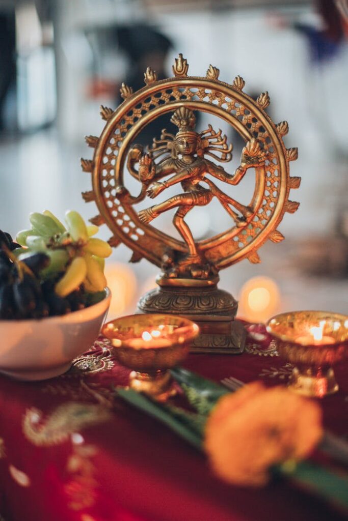 pexels photo 2072577 Intricate Shiva Nataraja statue surrounded by traditional offerings and candles on a vibrant altar.