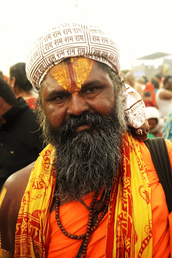 gallery-1 A serene portrait of a sadhu adorned in saffron robes and sacred markings, radiating devotion and peace.
