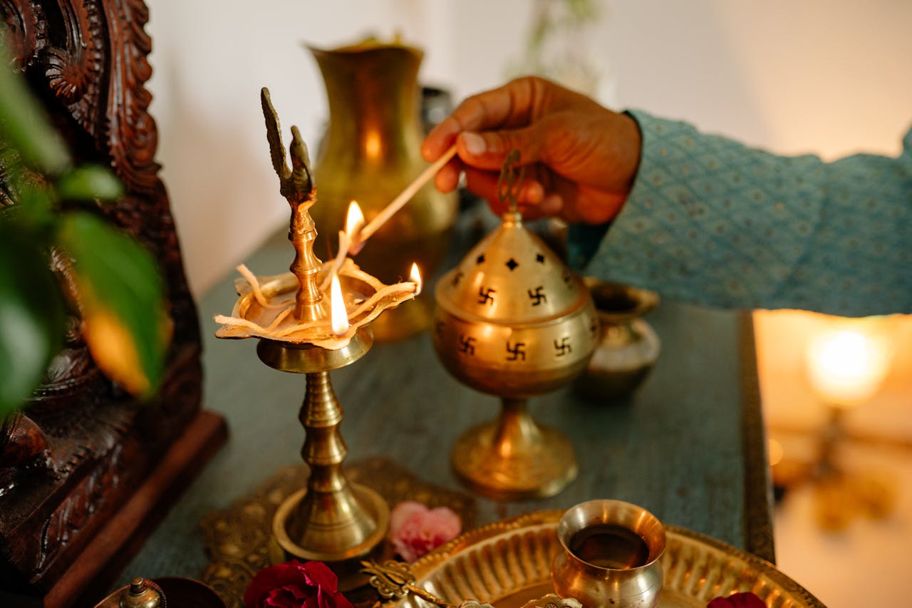 gallery-4 A hand performing a ritual with a brass lamp and incense burner, symbolizing spirituality.